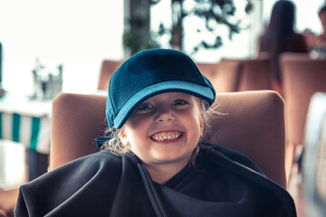 Happy beautiful smiling child girl in baseball cap mischievous portrait as happy childhood lifestyle