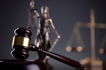 Law symbols composition. Law and justice concept.  Themis sculpture and judge’s gavel on gray...