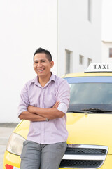 Hispanic ethnic taxi driver posing with his work vehicle. Yellow cab. Copy space.