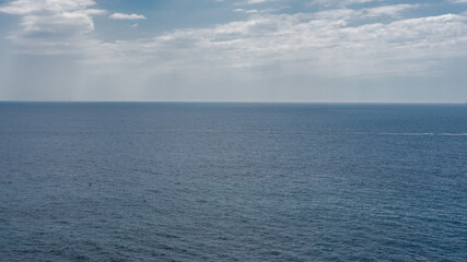 
blue ocean, horizon and the blue sky from the coast in summer - 528576346