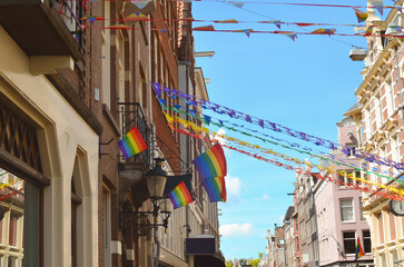 Fototapeta na wymiar Bright rainbow LGBT pride flags on building facade