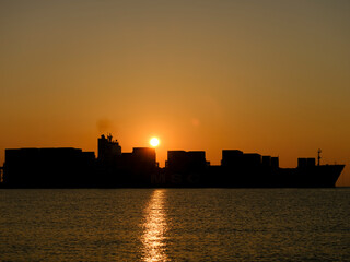 a ship leaving port at sunrise