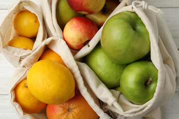 Cotton eco bags with fruits, closeup view