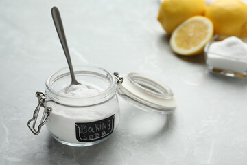 Baking soda and cut lemons on light marble table