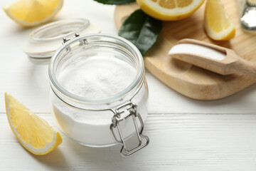 Baking soda and cut lemons on white wooden table
