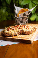 Milanese with topping. Milanesa covered with arugula, tomatoes, cheese. Breaded meat. Italian food. Fried meat. Beef, chicken meat, pork meat.