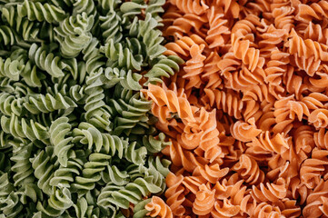 Background texture of tricolor fusilli pasta for traditional Italian and Mediterranean cuisine in a close up full frame view