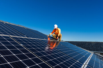 Solar panel technician with drill installing solar panels - obrazy, fototapety, plakaty