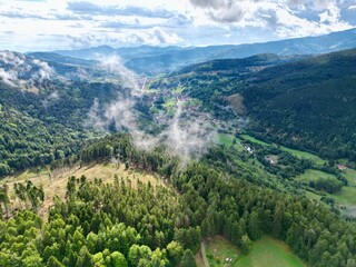Panoramic aerial drone view of Stosswihr, Munster and its valley on a summer day, behind small low clouds © Mickaël LEBRET