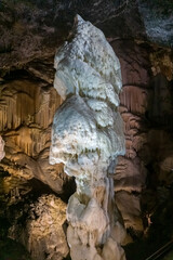 Vertical picture of a giant white stalagmite inside Postojna cave in Slovenia. 
