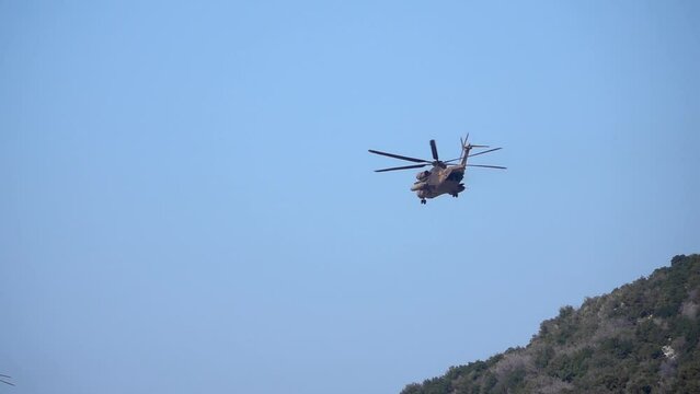 Large army helicopter flying in blue sky 

Israeli force in Action, Israel,golan Heights,February,16,2022, Slow motion shot
