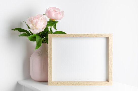 Frame mockup with pink peony flowers in vase, mockup for artwork presentation