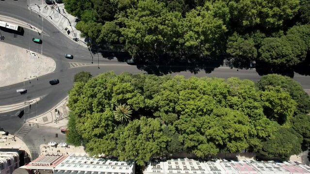 Aerial drone top down view of vehicles and pedestrians at tree-lined Avenida da Liberdade in Lisbon, Portugal