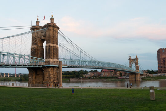 This is an image of the John A Roebling Suspension Bridge going across the river going from Ohio to Kentucky. This to me looks like a very old style bridge and has a pretty look to it.
