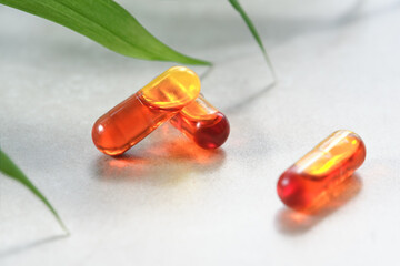 Curcumin in liquid form. Herbal capsules, herb turmeric capsules on neutral background with palm...