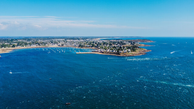 Aerial view of the Pointe de Kerpenhir at the entrance of the Gulf of Morbihan in Brittany, France - Port Navalo seaside village as seen from across the strait on a windy but sunny day