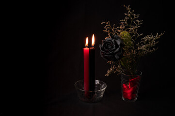 Black flower with black and red lit candle, Valentine's Day...magic attributes, Wiccan rituals, esoteric concept, Spells,..wicca concept.