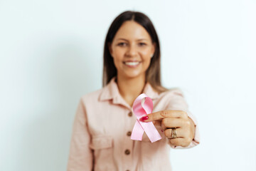 Woman holding pink ribbon, breast cancer awareness, pink october concept. Selective focus on pink ribbon - obrazy, fototapety, plakaty