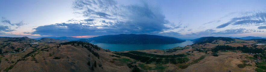 Aerial View of Canadian Landscape with Kalamalka Lake and Mountains. Colorful Cloudy Summer Sunrise. Near Vernon, Okanagan, BC, Canada. Nature Background Panorama