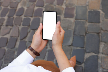 Closeup of woman with smartphone outdoors, above view