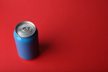 Blue can of energy drink on red background. Space for text