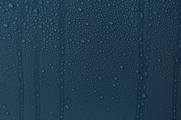 Many water drops on dark dusty blue background