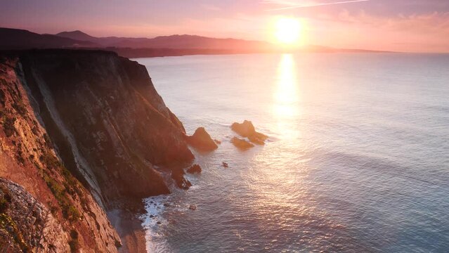 Sunset over rocky cliffs at Asturias coast in north Spain. View from Faro de Cabo Busto. Tourist attraction, place to visit.