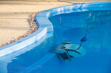 Robotic pool cleaner during on duty. Robotic is solutions for swimming pool care, deep clean pool...