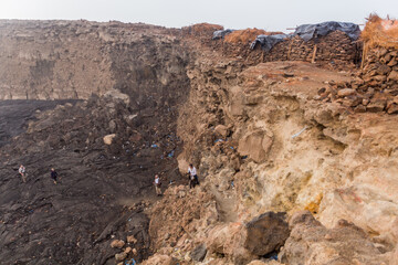 AFAR, ETHIOPIA - MARCH 26, 2019: Tourists climbing out of the Erta Ale volcano crater in Afar depression, Ethiopia