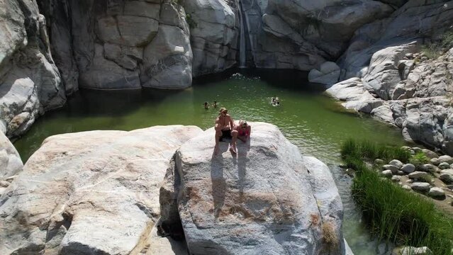 couple hikes to tropical waterfall Cobo san Lucus Mexico with giant rocks desert and forest surrounding it