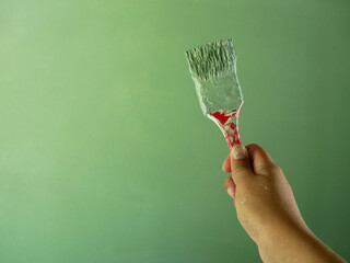 hand holding paint brush with green color.