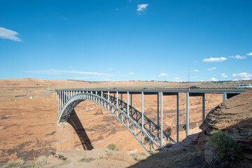Majestic Steel Arch Bridge Spanning Over a Vast Canyon Under a Clear Blue Sky 
