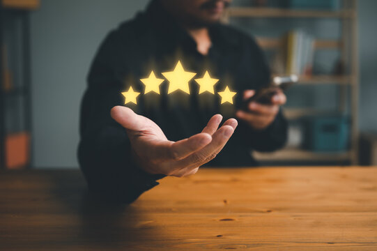 hand of customer or client holding the stars to complete five stars. with copy space. giving a five star rating. Service rating, satisfaction concept...