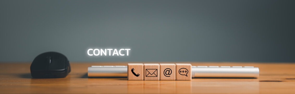 Website page contact us or e-mail marketing concept, Customer support hotline Contact us people connection. cube wood with the email, call phone, address, Chat message icons. on keyboard computer...