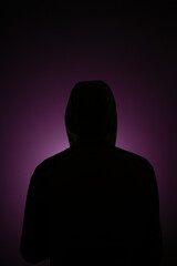 Anonymous alone in the dark back photo wearing hoodie purple light background