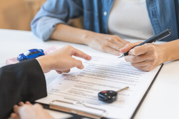 Business car rental company service, hand of agent dealer is pointing to purchase contract of tenant to sign signature on document, new owner after signed rental , vehicle sales agreement.