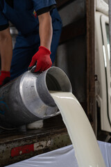 Milk being emptied from a container in a dairy factory