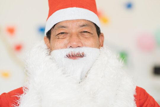 Close up of happy Santa Claus with smile wears red headwear and white beard
