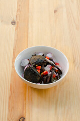 Small black crab sour salad on wooden background, Thai traditional food