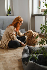 Ginger Woman with three dogs cuddling on the floor Pets friends at home with human. Big dogs Golden...