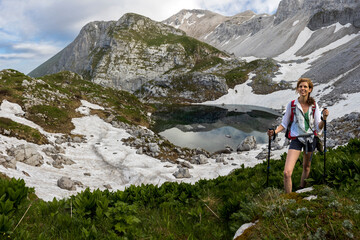 Naklejka na ściany i meble Mid Adult Woman Hiker on a Adventure Journey in Early Springtime Julian Alps near Lake Of Luznica - Slovenia