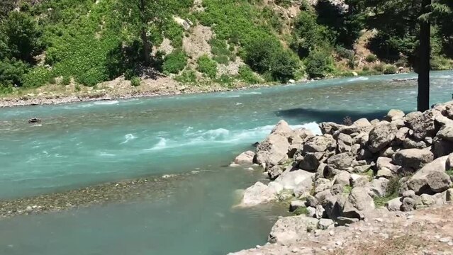 Blue crystal clear water of river swat recorded from a moving car