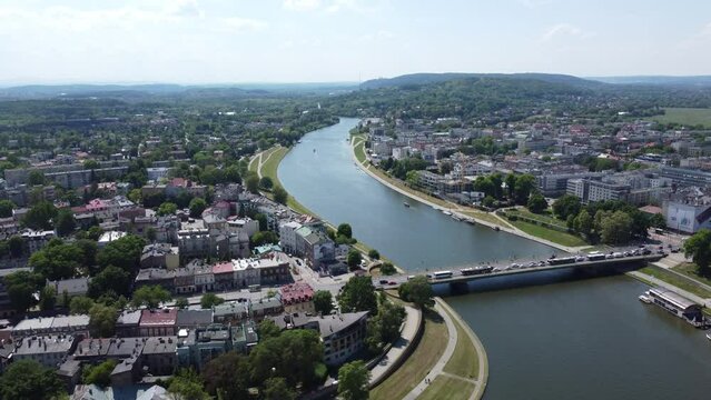 Flyover of Wisła Vistula River near the city center of Krakow, Poland, a Polish cultural capital, with medieval and renaissance architecture, bridge and cars - 4K 30FPS Smooth Tracking Forward Right