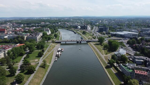 Flyover of Wisła Vistula River near the city center of Krakow, Poland, a Polish cultural capital, with medieval and renaissance architecture, bridge and cars, university and expo - 4K 30FPS Forward