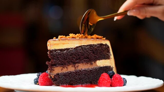 Mocha cake being cut it in slow motion hand spoon woman