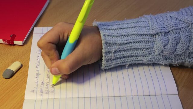 Close-up of a student's hands in a notebook write in English. Schoolboy is on a mission. Educational school concept.Elementary and middle school. UHD 4K.
