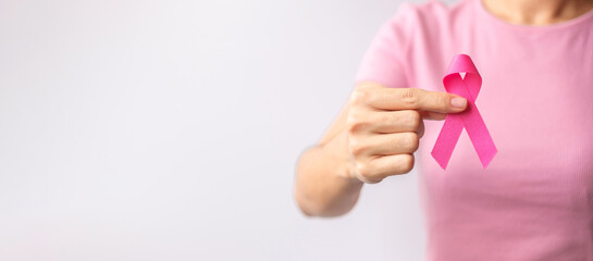 Pink October Breast Cancer Awareness month, woman hand hold pink Ribbon and wear shirt for support people life and illness. National cancer survivors month, Mother and World cancer day concept