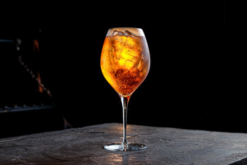 Orange cocktail Aperol Spritz on a black background served in a glass with ice