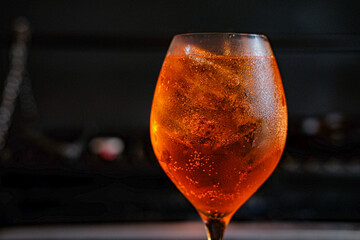 Orange cocktail Aperol Spritz on a black background served in a glass with ice