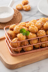 Delicious French Chouquette Choux Pastry dessert Pearl Sugar Puff on white marble background.